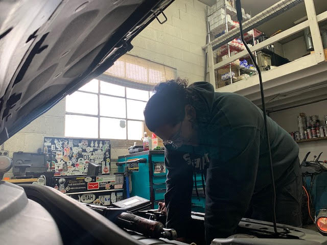 Sebastian Sanchez repairing a car